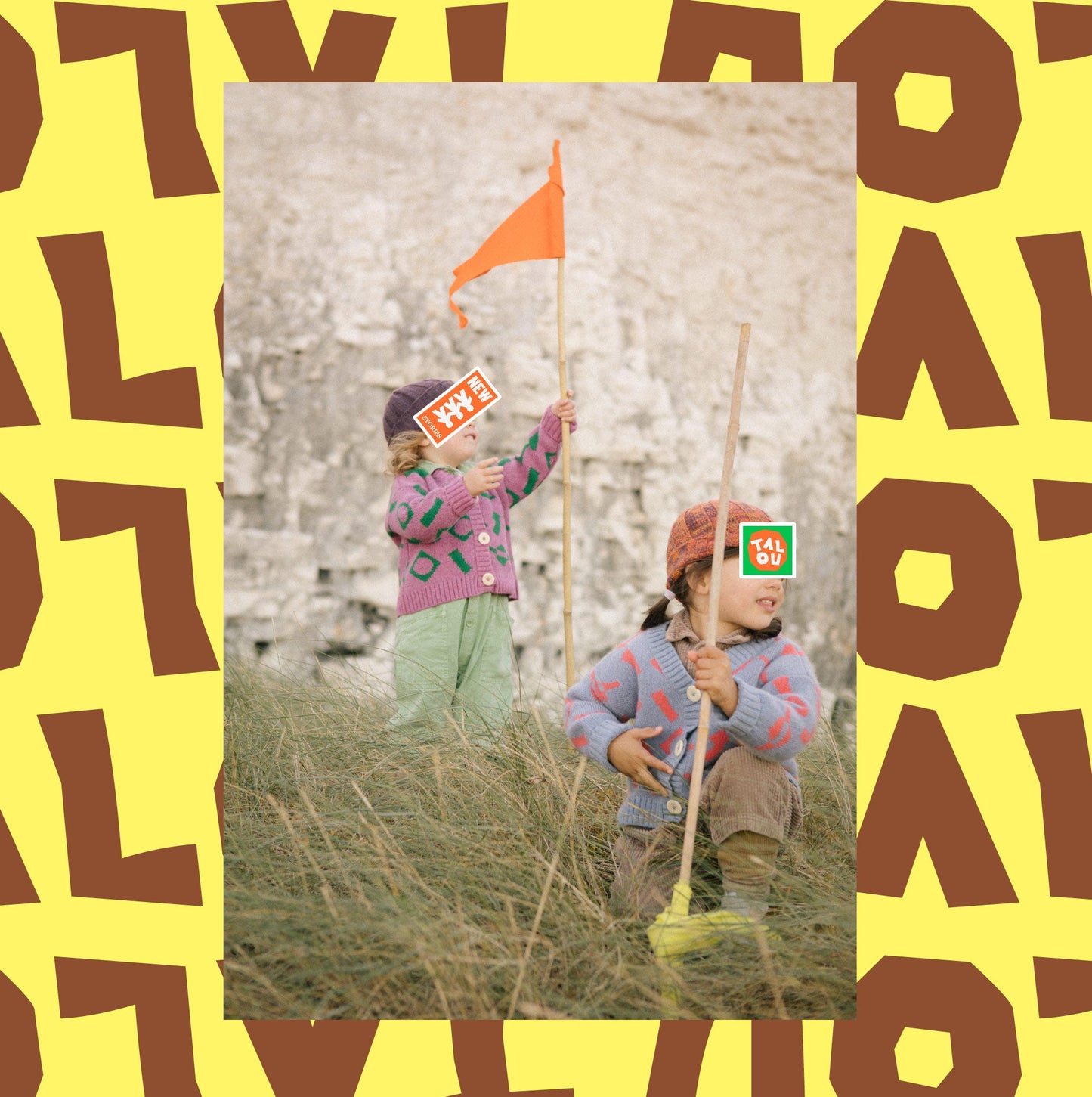  Children in wool knitwear holding flags on sand dunes.