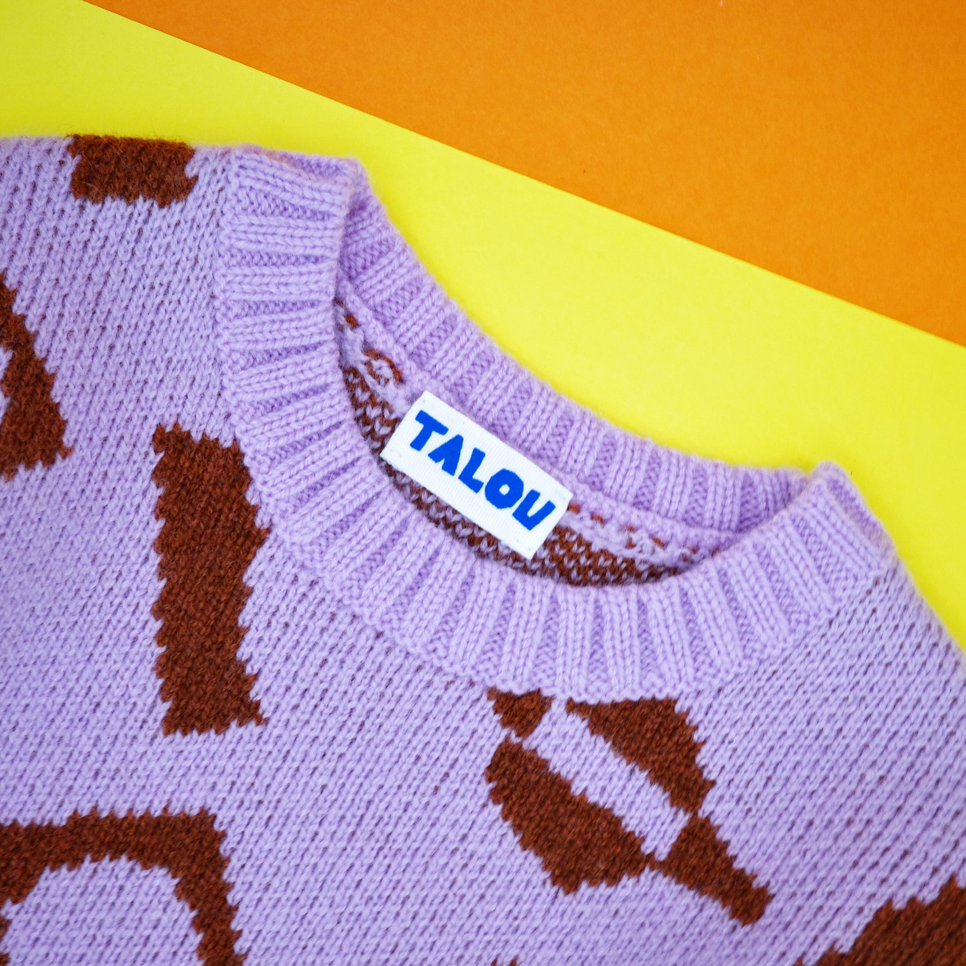 Neckline of children's knitted wool jacquard jumper in lilac and brown.