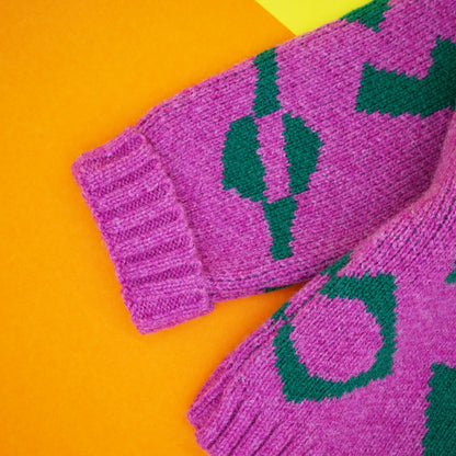 Fold back cuff of children's jumper in pink and green wool jacquard knit.